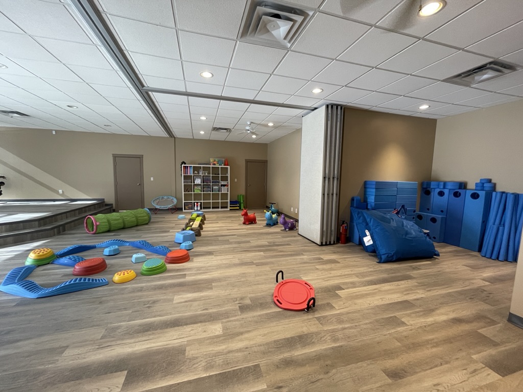Kids climbing and balancing on giant blue foam blocks in the Move Lab